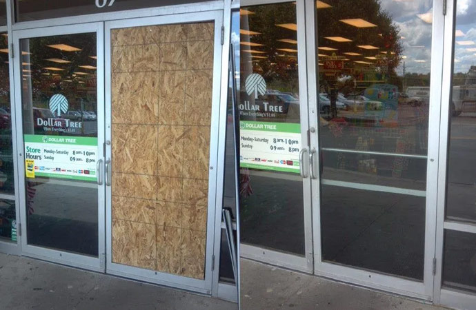 boarded up glass door at a commercial business
