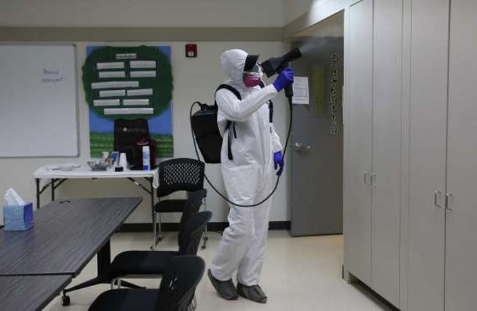 biohazard tech disinfecting an office