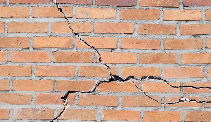 several cracks in a brick wall - structural damage